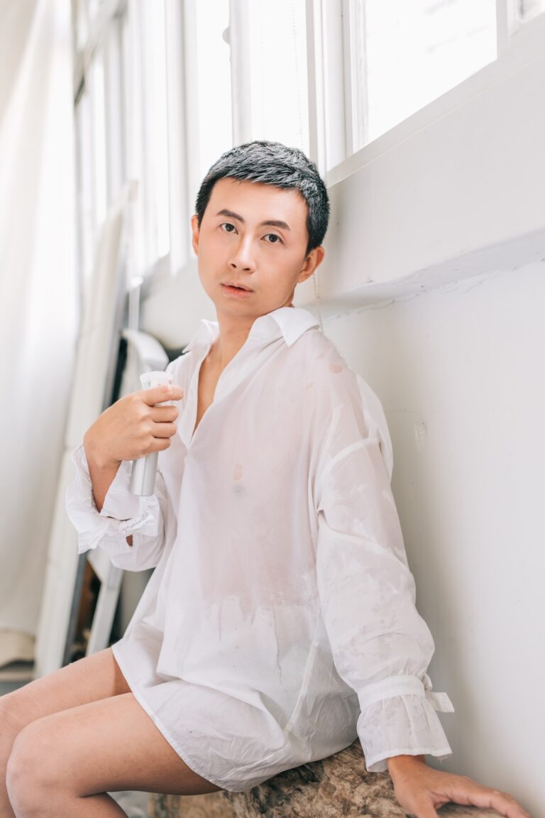 呱吉穿白襯衫坐在窗邊